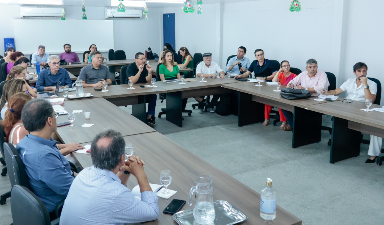 grupo de pessoas reunidas em volta de uma mesa